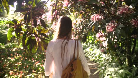 Siguiendo-A-Una-Hermosa-Mujer-Caminando-Entre-árboles-Tropicales-En-Flor.
